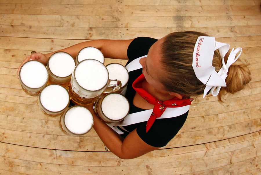 A waitress carries the traditional 1-litre beer mugs at the opening of the Munich Oktoberfest